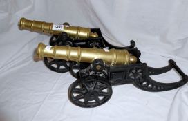 A pair of brass cannons on cast metal bases