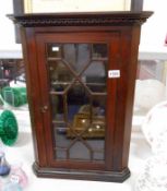 A small astragal glazed wall corner cabinet