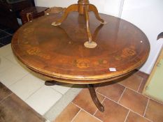 A marquetry inlaid circular dining table