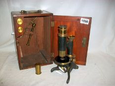 A late 19th century microscope complete with condenser bullseye and lenses in mahogany case