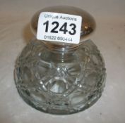 A cut glass inkwell with silver plated top