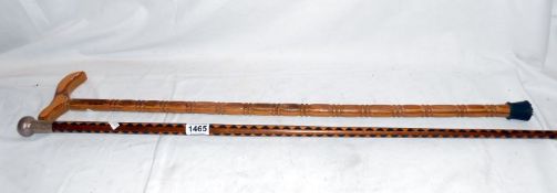 A silver topped marquetry walking stick and a carved stick