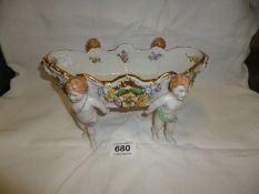 A Von Schierholz porcelain bowl supported by cherubs