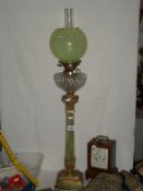 A Victorian oil lamp with marble column and vaseline glass globe shade