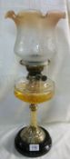 A Victorian oil lamp with brass column on pot base, glass font and later shade