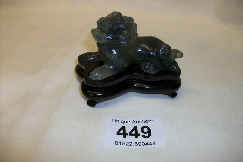 A jade dog of foo on wood stand