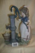 A Lladro figure of a girl by a waterpump