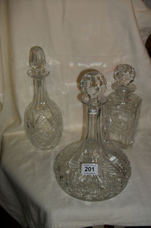 A cut glass ship's decanter and 2 others