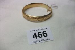 A 9ct gold engraved bangle