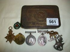 A WW1 tin with medals and badges