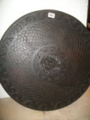 A heavily carved circular wall plaque