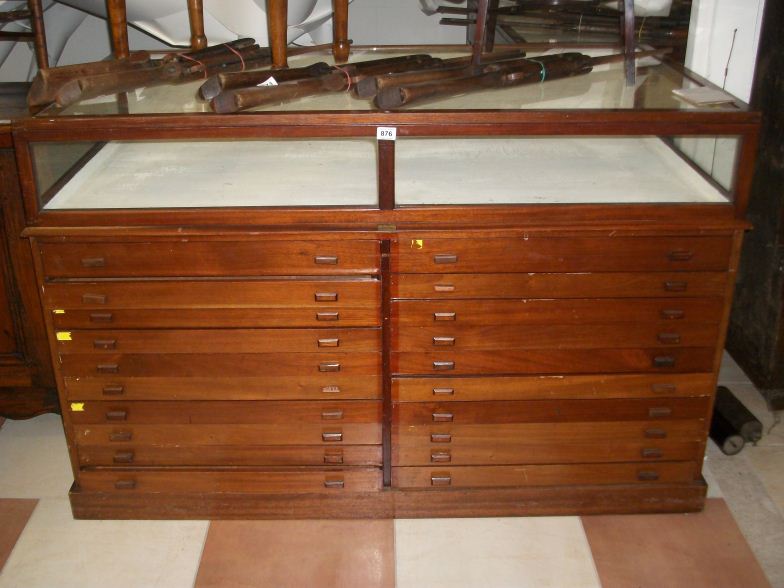 A large glass topped shop counter with 18 drawers