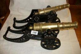 A pair of cast brass cannons on iron bases