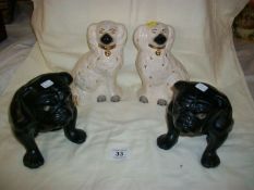 A pair of Staffordshire spaniels and a pair of black pug dogs