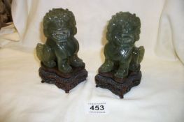 A pair of jade Dogs of Foo on wood stands