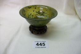 A jade bowl on wood stand