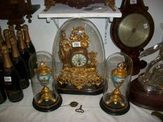 A Victorian French clock garniture under glass domes