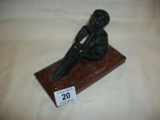 A bronze seated nude figure on marble base