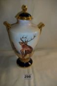 An Aynsley hand painted lidded vase 'The Red Deer' signed J Shaw and still with Harrod's original