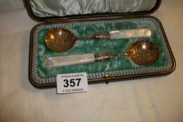 A cased pair of silver plated spoons with mother of pearl handles