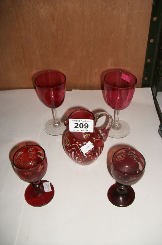 A Cranberry glass jug and 4 wine glasses