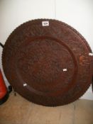 A heavily carved circular wall plaque