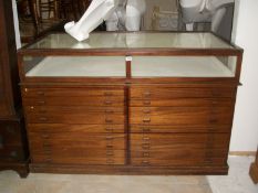 A large glass topped shop counter with 18 drawers