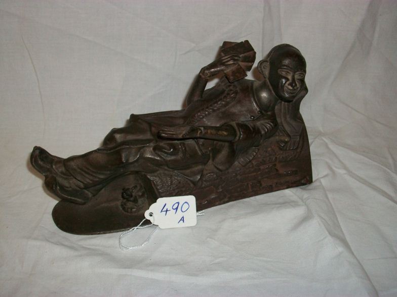 A cast iron reclining China man money box by J & E Stevens & Co.,