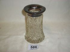 A cut glass vase with silver rim (silver has some dints)
