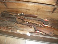 A Pine box (118cm x 46cm x 39.5cm) containing a quantity of old wooden rifle stocks