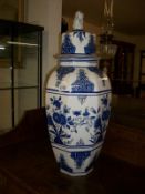 A large blue and white Oriental style lidded vase