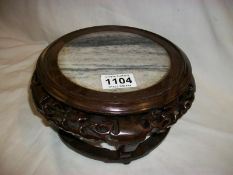 An Oriental carved stand with marble inset