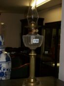 A Victorian brass column oil lamp with chimney