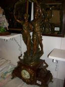 A French mantel clock in red marble and surmounted 2 spelter figures