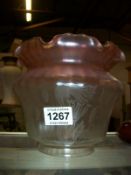An etched glass lamp shade with cranberry glass rim