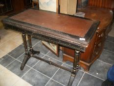 An ebonised fold over table