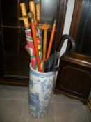 A blue and white stick stand with collection of walking sticks