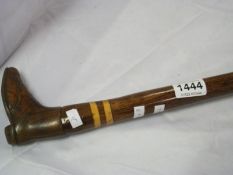 A walking stick with carved boot handle