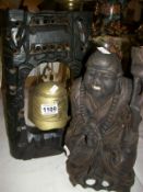 A carved wood Buddha and a temple bell