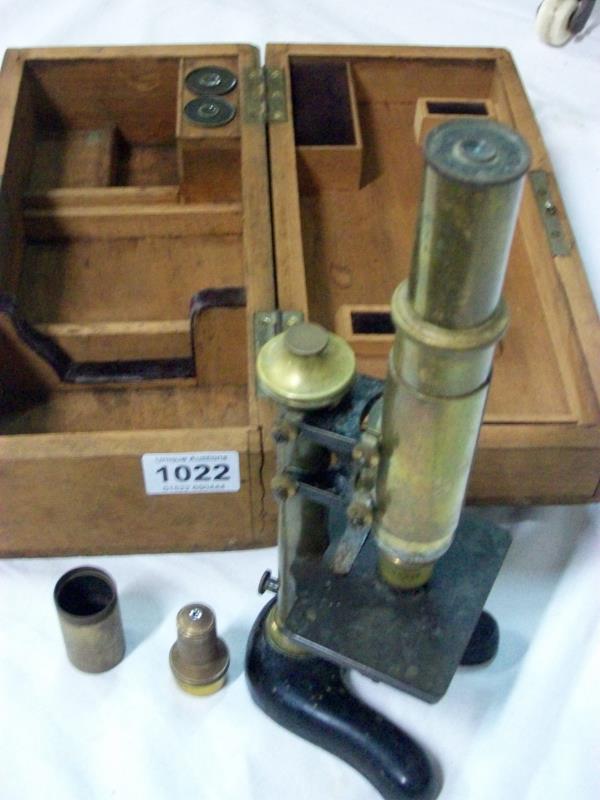 A brass microscope in wooden case