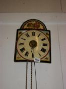 A wall clock with painted face and 2 weights