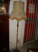 A brass standard lamp with shade