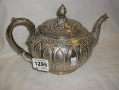 An ornate silver plated teapot