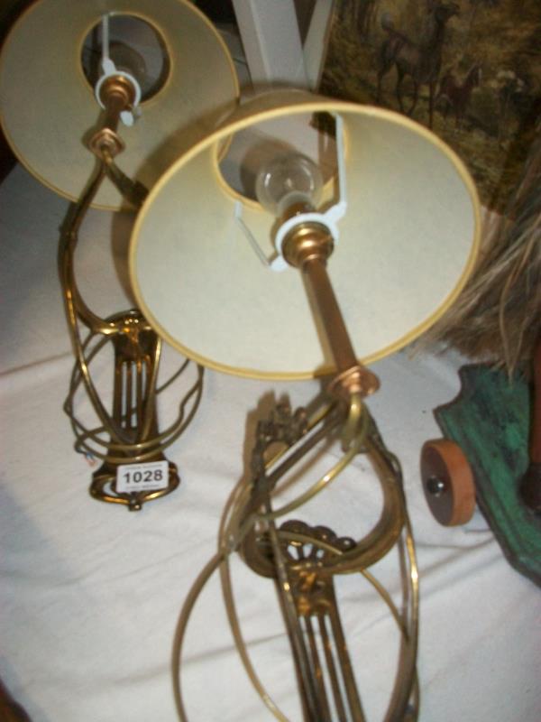 A pair of Art Nouveau brass wall lights complete with shades