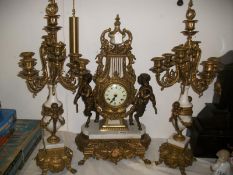 A superb 3 piece Victorian clock garniture with clock surmounted by 2 hoof footed cherubs and pair