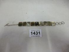 A silver bracelet set grey stones
