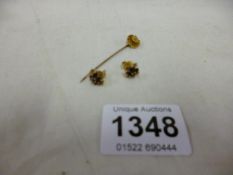 A 14k stick pin and a pair of earrings