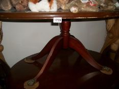 A mahogany oval table with brass Lions paw feet