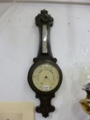 A carved oak barometer