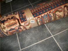 A blue and terracotta patterned rug, 320 x 220 cm